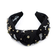 Load image into Gallery viewer, Black headband adorned with gold and silver embellishments, including stars, cheerleaders, and rhinestones, exuding a playful and glamorous vibe.