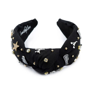 Black headband adorned with gold and silver embellishments, including stars, cheerleaders, and rhinestones, exuding a playful and glamorous vibe.