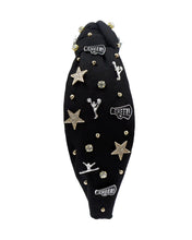 Load image into Gallery viewer, Black headband adorned with gold and silver embellishments, including stars, cheerleaders, and rhinestones, exuding a playful and glamorous vibe.