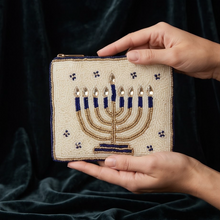 Load image into Gallery viewer, Hands holding a beaded menorah pouch to show its compact size.