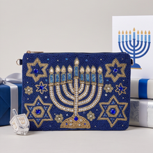 Load image into Gallery viewer, 1. Hanukkah gift styling featuring a navy blue hand-beaded pouch with a gold and crystal menorah design.