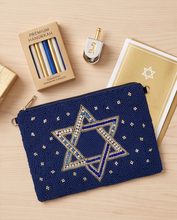 Load image into Gallery viewer, Elegant navy blue Star of David beaded pouch displayed with a traditional Hanukkah menorah and festive decorations.