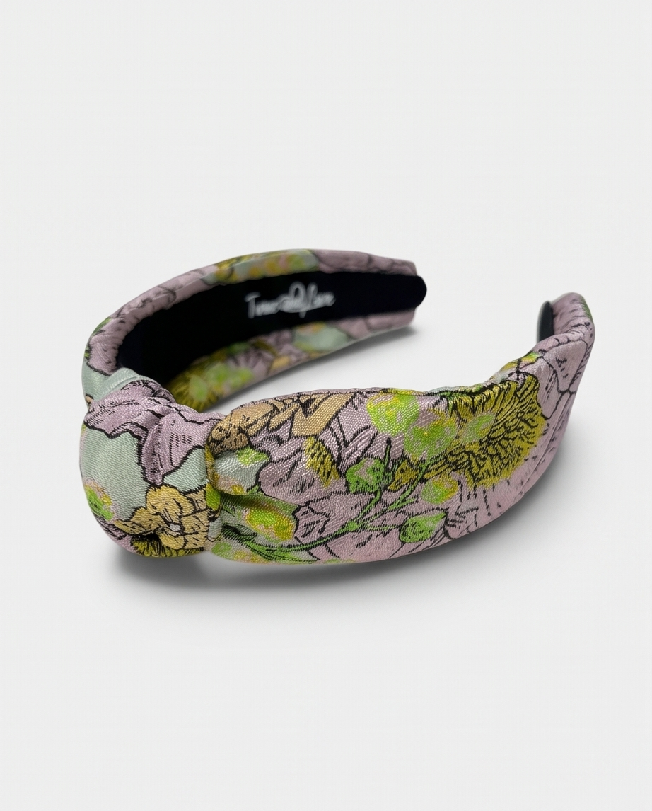 Wide padded floral headband with a voluminous silhouette.