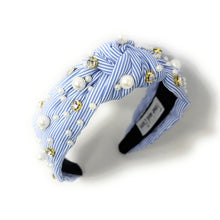 Load image into Gallery viewer, A blue and white striped headband adorned with pearls and gold beads. It features a knot design, creating an elegant and stylish accessory.