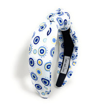 Load image into Gallery viewer, A white padded headband features a blue and yellow concentric circle pattern, exuding a playful vibe.