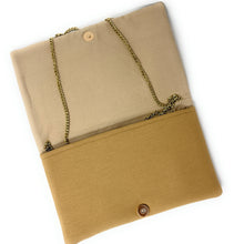 Load image into Gallery viewer, A fabric clutch or envelope-style bag shown from above on a white background. The bag has a two-tone design with a light beige top section and a mustard yellow bottom section, accented by a gold-tone chain strap and a snap button closure.