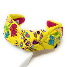Load image into Gallery viewer, Chic outdoor look showcasing a vibrant yellow floral headband and handcrafted tropical bird beadwork earrings.