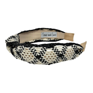 A black ivory raffia woven headband with a monochrome ivory and beige pattern, featuring a knotted designed.