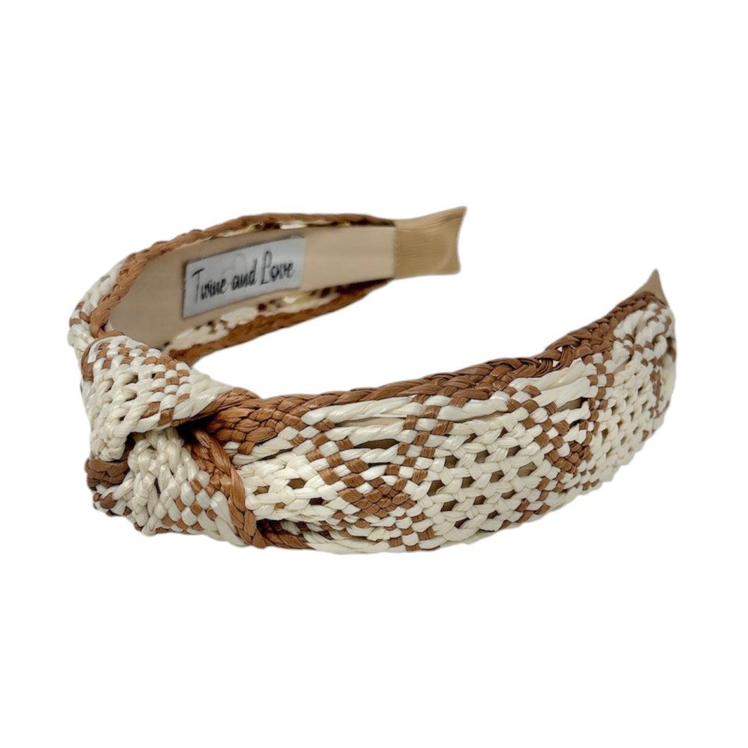 A raffia woven headband with a monochrome ivory and brown pattern, featuring a knotted design.