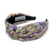 Load image into Gallery viewer, Floral headband featuring a twisted design with purple, green, and beige hues. The soft fabric and intricate pattern convey an elegant, feminine tone.