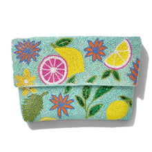 Load image into Gallery viewer, Hand beaded lemon and floral clutch featuring colorful citrus slices, flowers, green leaves, and an aqua blue background.