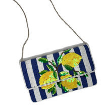 Load image into Gallery viewer, A rectangular shoulder bag with a navy and white striped body, embellished with three large yellow sequined lemons and green sequin leaves on the front flap. The bag has a thin silver chain strap and is photographed on a plain white background.