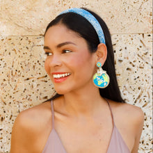 Load image into Gallery viewer, Chic accessory styling with planet-inspired statement earrings and a sparkly blue hairband.