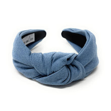 Load image into Gallery viewer, A blue fabric headband with a centered knot design sits on a white background. The soft texture and simple style convey a casual, elegant tone.