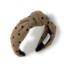 Load image into Gallery viewer, Beige headband with black heart patterns on a white background