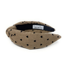 Load image into Gallery viewer, tan headband with black heart patterns on a white background