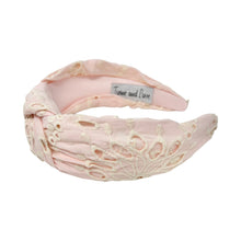 Load image into Gallery viewer, Pink headband with intricate white floral embroidery, displayed in a side view. The soft texture and elegant design convey a stylish, timeless appeal.