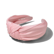 Load image into Gallery viewer, A light pink twisted fabric headband with a knotted front detail, displayed on a clean white background with a soft shadow.