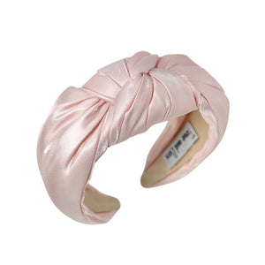 Pink satin headband on a white background