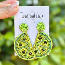 Load image into Gallery viewer, Hand beaded lime slice earrings with green citrus design on display card