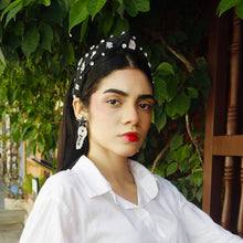 Load image into Gallery viewer, Woman wearing real estate inspired statement earrings with embellished black headband and white blouse.