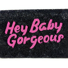 Load image into Gallery viewer, Fashion portrait of a woman showcasing a black beaded clutch with vibrant pink script lettering and intricate beadwork.