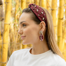 Load image into Gallery viewer, Woman wearing a burgundy headband and earrings with a bamboo background