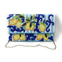 Load image into Gallery viewer, A beaded clutch bag featuring a lemon and scroll pattern on a light blue and white striped background, with a silver chain strap, photographed on a white background.