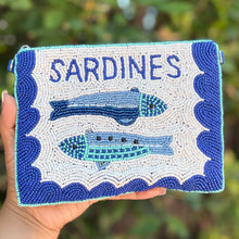 Load image into Gallery viewer, Hand-beaded sardine pouch featuring two detailed fish motifs, bold blue wave-inspired borders, and “SARDINES” lettering on a crisp white beaded background.