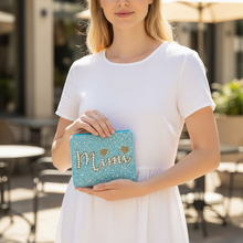 Load image into Gallery viewer, A woman in a white dress holding a glittery turquoise blue clutch bag with 'Mimi' written in gold glitter letters.