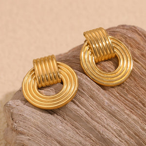 18k Gold plated drop earrings on a textured beige surface