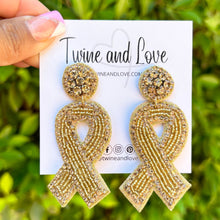 Load image into Gallery viewer, Curly-haired model showcasing a wide cognac brown headband and sparkling gold ribbon-shaped earrings against a colorful artistic backdrop.