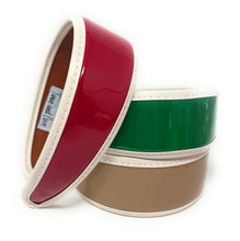 Load image into Gallery viewer, Wide patent leather-look headbands displayed in a stack, showcasing red, green, and beige color options.