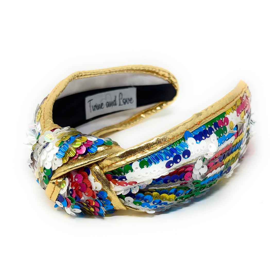 Gold padded headband adorned with colorful sequins, displaying a vibrant, playful design. 