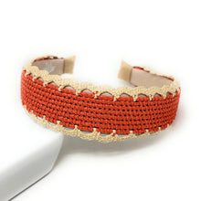 Load image into Gallery viewer, A woven cuff bracelet in terracotta red with a cream scalloped lace trim, displayed on a white surface.