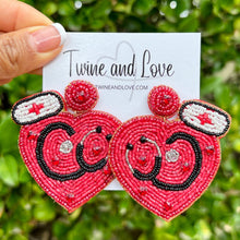 Load image into Gallery viewer, Fun healthcare-themed earrings with a red heart, stethoscope motif, and sparkling embroidered accents.