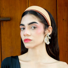 Load image into Gallery viewer, Elegant model showcasing a neutral tan headband and beaded seahorse earrings, paired with a chic black asymmetrical top.