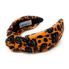 Load image into Gallery viewer, Orange knotted headband with black Halloween-themed prints, featuring pumpkins and cats. The design is playful, capturing a festive Halloween vibe.