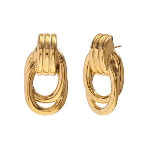 Gold-tone earrings with oval loops and ridged details, resembling linked chains. They convey a modern and elegant style, set against a plain white background.