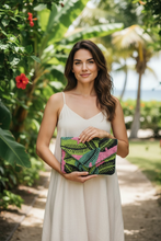 Load image into Gallery viewer, Woman holding a colorful clutch in a tropical setting