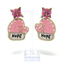 Load image into Gallery viewer, Festive pink mitten earrings with shimmering bead embroidery, jeweled accents, and bright pink crystal tops against a natural outdoor background.
