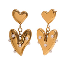 Load image into Gallery viewer, Gold heart-shaped earrings with pearl accents on a white background