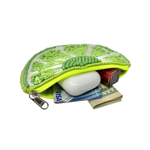 Green beaded coin purse with money and a card inside on a white background