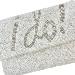 Elegant white clutch with sparkling beads, featuring the words "I Do!" in bold, silver lettering. It has a silver chain, conveying a bridal theme.