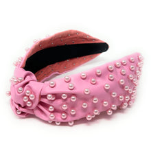 Load image into Gallery viewer, Elegant pink statement headband with pearl accents styled for a glamorous outfit, adding texture and sophistication to the look.