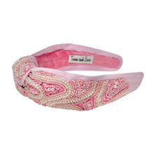 Load image into Gallery viewer, Pink padded headband adorned with intricate beadwork in swirling patterns. It features a central knot, creating an elegant and textured design.