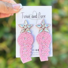 Load image into Gallery viewer, Handmade pink  earrings with crystal embellishments held outdoors in natural light.