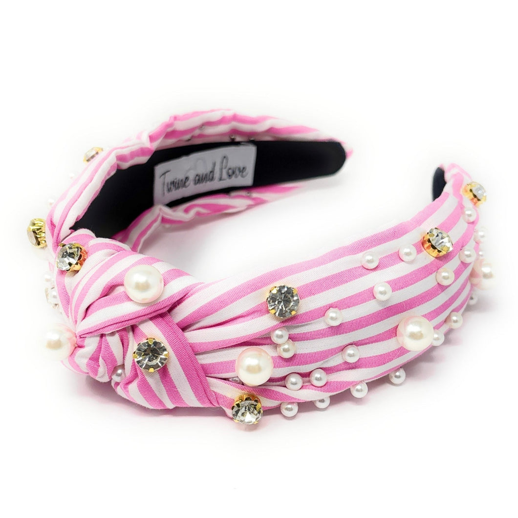Pink and white striped headband with pearls and crystals on a white background