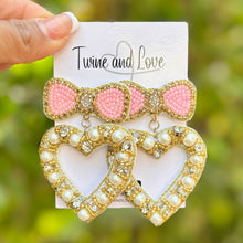 Load image into Gallery viewer, heart with bow jeweled Earrings, pink bow heart valentines Earrings, Valentines Day Earrings, Valentines Beaded Earrings, Valentines Heart earrings, sweetheart earrings, valentine’s day beaded earrings, dainty valentines beaded earrings, valentines beaded earrings, unique earrings, Valentine’s day earrings, tween girls accessories, Valentine’s day accessories, Best selling items, Valentines accessories, pearly heart earrings, custom earrings, gifts for her, handmade gifts, unique valentines heart earrings
