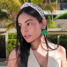 Load image into Gallery viewer, Woman wearing a beige vest and blue jeans with decorative headband and clover leaf earrings.